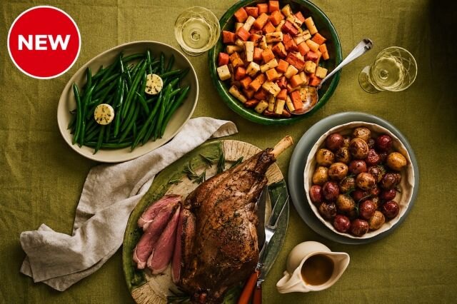 Roasted leg of lamb with green beans, roasted carrots and potatoes, served as a festive holiday dinner meal.